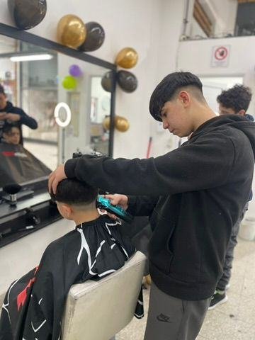Alumno practicando corte de barbería