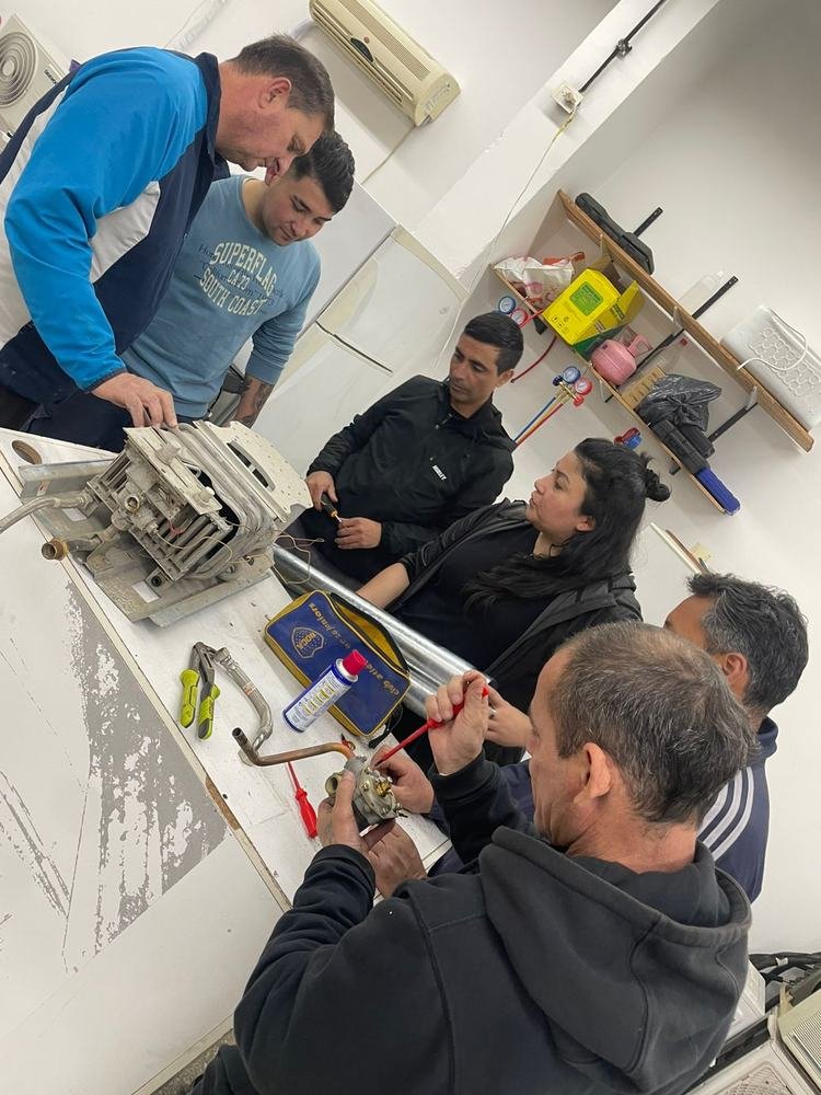 Grupo reparando el motor de un lavarropas