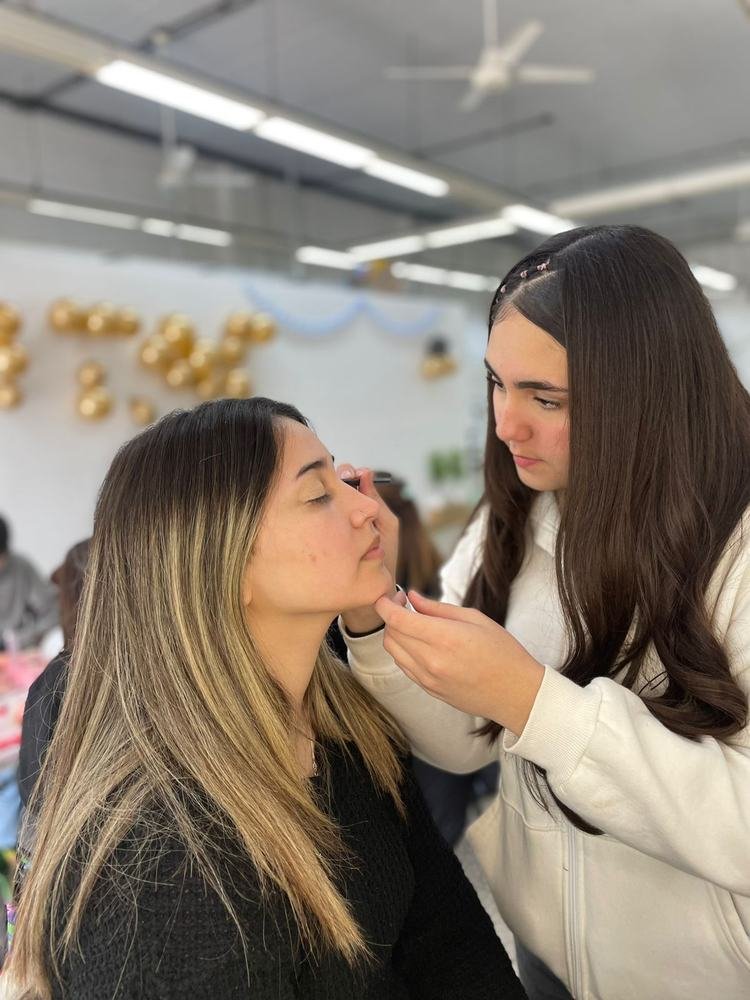 Práctica de maquillaje en un evento del instituto